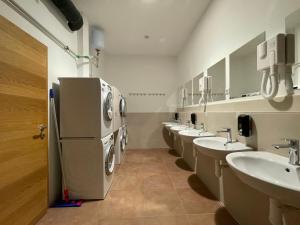 卢布尔雅那Sleep&Go Hostel Ljubljana的浴室设有一排盥洗盆和一台冰箱