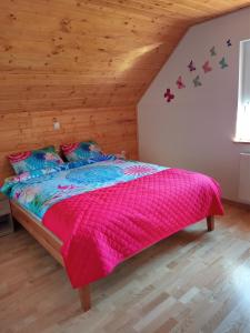 罗加斯卡斯拉提纳Ranč Stojnšek的一间卧室配有一张带粉色毯子的大床