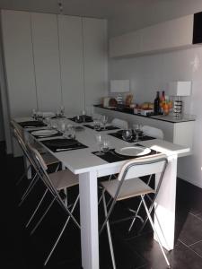波尔尼谢Magnifique Penthouse Pornichet的厨房配有长白桌子和椅子