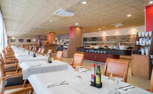 卡里拉圣莫尼卡梅德普拉亚酒店 的一间带白色桌椅的餐厅和一间厨房