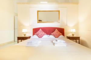 莱切Dimora Le Tre Muse Guesthouse的一间卧室配有一张带两盏灯的大型白色床。