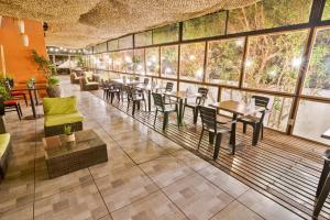 卡拉马卡拉马吉尔公寓式酒店的餐厅设有桌椅和大窗户。