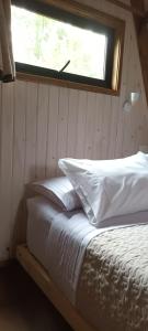 MolcoMolco Alpina的窗户客房内的一张带白色枕头的床