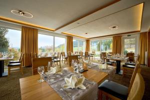内森尔旺尼瑟尔万格酒店的餐厅设有桌椅和大窗户。