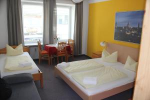 慕尼黑Hotel Pension am Hauptbahnhof的酒店客房设有两张床和一张桌子。