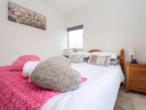 坎伯恩Sandyfeet的卧室配有白色床和粉色毯子