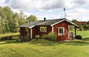 Knapasjö2 Bedroom Amazing Home In Mjback的田野中的红色房子,有院子