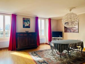 拉罗谢尔L'Appart Du Vieux Port的一间设有桌子和红色窗帘的用餐室