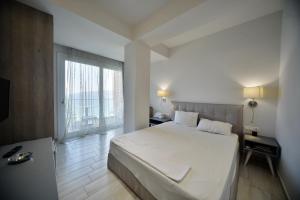 劳特拉奥雷亚斯埃利尼斯Hotel Kakanakos的一间卧室设有一张大床和一个大窗户