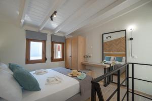 霍拉斯法基翁Jacuzzi maisonette in Sfakia center 'New 2023'的小房间设有一张床和一张书桌