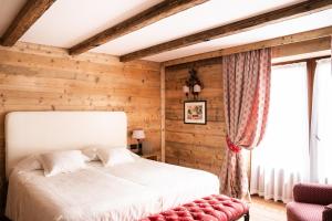 库马约尔Auberge de La Maison的一间卧室设有一张床和木墙