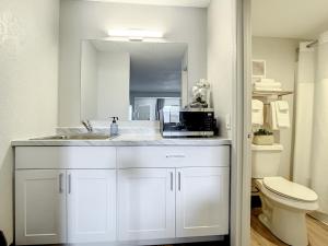 基西米Stayable Kissimmee West的白色的浴室设有水槽和微波炉。