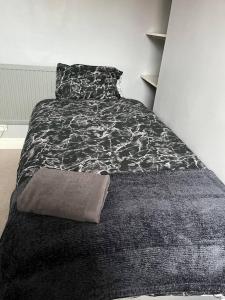 利物浦2 bed house near Sefton Park & Lark Lane的一间卧室配有一张带黑白毯子的床