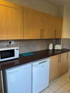 利物浦2 bed house near Sefton Park & Lark Lane的厨房配有白色微波炉和冰箱。