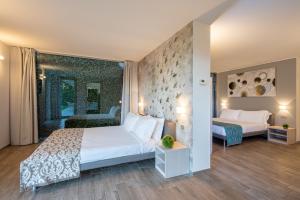 奥利维托拉里奥Villa Costanza- private seasonal warm pool, steam room, sauna-Bellagio Village Residence的一间带白色大床的卧室和一间带两张床的房间