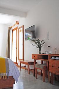 圣克里斯托瓦尔-德拉斯卡萨斯Casa Cafeólogo的一间卧室配有一张桌子和一台墙上的电视。