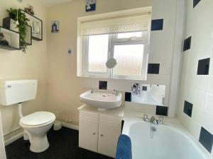 大雅茅斯Cosy and Comfortable Holiday Chalet 10 minutes walk to the beach, Norfolk的浴室配有卫生间、盥洗盆和浴缸。