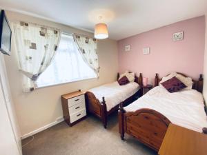 大雅茅斯Cosy and Comfortable Holiday Chalet 10 minutes walk to the beach, Norfolk的带窗户的客房内设有两张单人床。