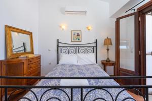 锡蒂亚Maisonette in Roussa Ekklisia的一间卧室配有一张带镜子和梳妆台的床