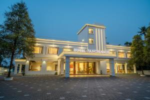 埃尔讷古勒姆Hotel Panoramic的白色的建筑,上面有读寄主餐厅的标志