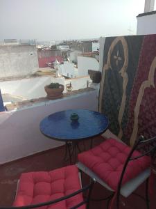 拉巴特Dar Sam - Pacha Room的阳台配有一张桌子和两把椅子以及一张桌子