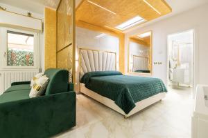 博洛尼亚FASHION APARTMENT GOLD Bologna的一间卧室配有绿色的床和绿色沙发