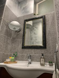 德布勒森Dimora Apartman的浴室设有白色水槽和镜子