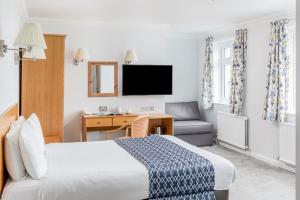 纽基凯布瑞尼酒店的酒店客房配有一张床、一张桌子和一把椅子。