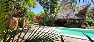 马林迪Lions' Luxury Eco Resort & Spa的一个带游泳池和红椅的度假胜地
