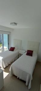 埃斯特角城Jose Luis Arenas del Mar Torre 1的白色客房的两张床,设有窗户