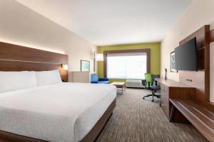 普弗拉热维尔Holiday Inn Express & Suites Austin North - Pflugerville, an IHG Hotel的一间酒店客房,配有一张大床和一台平面电视