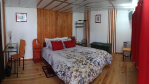英雄港Alojamento Raminho dos Açores的一间卧室配有一张带红色枕头的床