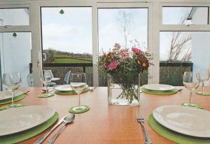 卡林顿Tamar Valley, Cornwall的一张桌子,上面有盘子和玻璃杯,花瓶