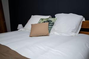 BourdaLA RESIDENCE DU ROCHER的白色的床、白色枕头和棕色枕头
