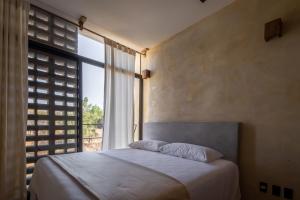 埃斯孔迪多港Casa Kame的一间卧室设有一张床和一个大窗户