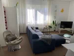 莱比锡Apartment Leipzig Zentrum mit Tiefgarage的客厅配有蓝色的沙发和椅子