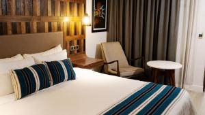 瓜达拉哈拉Hotel Indigo Guadalajara Expo, an IHG Hotel的配有一张床和一把椅子的酒店客房