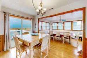 WavesLooney Dunes的一间带桌椅的用餐室和一间海景用餐室