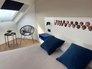 菲尼斯特雷Hotel Playa de Sardiñeiro的一间卧室配有一张带蓝色枕头的床和一把椅子
