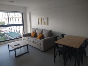 萨尔塔Departamento equipado en mejor zona del centro de Salta的客厅配有沙发和桌子