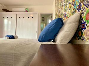 女人岛Casa María的一间卧室配有一张带蓝色枕头的床