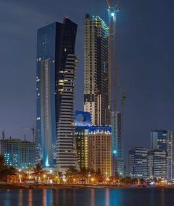 吉达Damac Al Jawharah Tower Apartments的城市天际线,夜晚有高楼