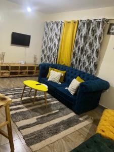 尼耶利Ruby Modern Homes-2br-Nyeri, King'ong'o-Knights的客厅配有蓝色的沙发和黄色的桌子
