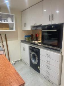 加利布港One bedroom apartment at marina city portghalib的厨房配有洗衣机和微波炉。