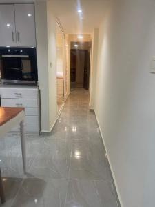 加利布港One bedroom apartment at marina city portghalib的厨房配有白色橱柜和瓷砖地板。