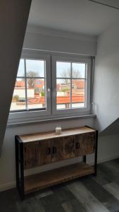 海利根港Apartment "The Loft" in Heiligenhafen的带2扇窗户的客房内的木桌