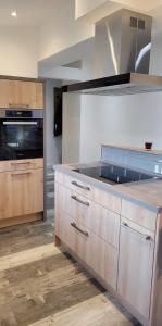 海利根港Apartment "The Loft" in Heiligenhafen的厨房配有木制橱柜和炉灶烤箱。