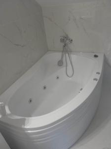 瑟切莱Izabella Guest House的白色浴室内的白色浴缸