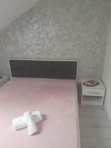瑟切莱Izabella Guest House的粉红色床顶上的十字架