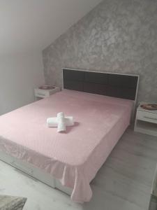 瑟切莱Izabella Guest House的粉红色的床,上面有一条毛巾